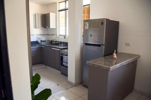 a kitchen with a stainless steel refrigerator and a counter at Apartamento entero 2 cuartos 2 baños in Piura
