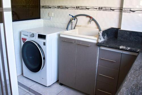y cocina con lavadora y fregadero. en Apartamento entero 2 cuartos 2 baños, en Piura