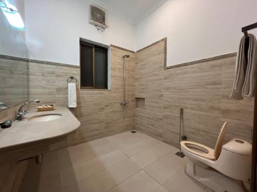 a bathroom with a toilet and a sink and a shower at Rhodium Hotel ONE in Islamabad