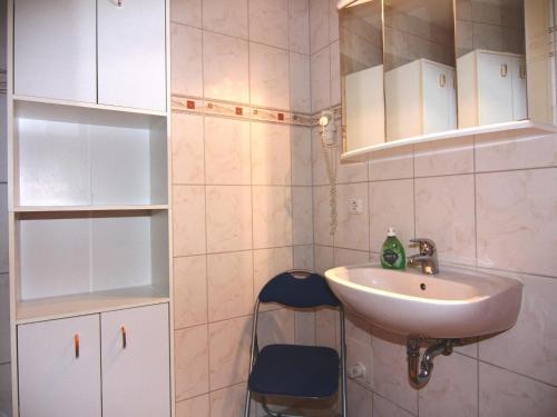 a small bathroom with a sink and a chair at Terraced house, Zingst in Zingst