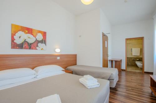 a hotel room with two beds and a bathroom at Hotel Del Buono Wellness & Medical Spa in Chianciano Terme