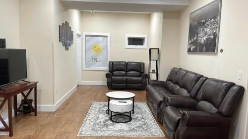 uma sala de estar com um sofá de couro e uma televisão de ecrã plano em luxurious big house em Jersey City