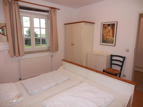a bedroom with a bed and a window and a chair at Apartments Blue House, Putbus in Putbus