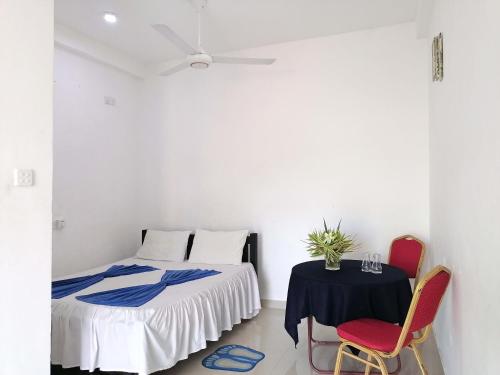 Hotel Water Nest في Etagama: غرفة نوم بسرير وطاولة وكراسي