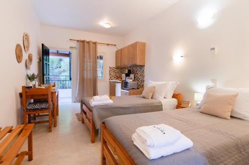 a living room with two beds and a kitchen at Almyra Apartments & Studios in Agios Gordios