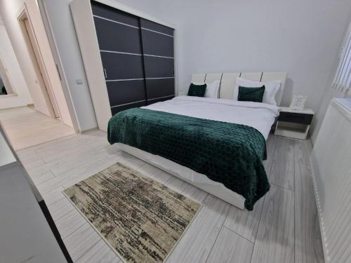 a bedroom with a large bed with a green blanket at Blue apartaments in Cluj-Napoca