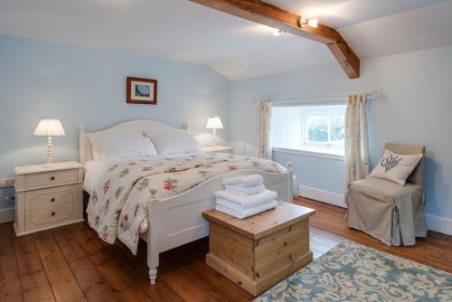 une chambre avec un lit, une chaise et une fenêtre dans l'établissement Well House, à Cornhill-on-tweed