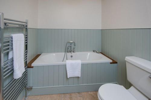 y baño con bañera y aseo. en Well House, en Cornhill-on-tweed