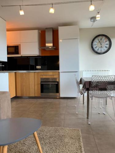 Una cocina con una mesa y un reloj en la pared. en Appartement vue Mer à Porticcio, en Porticcio