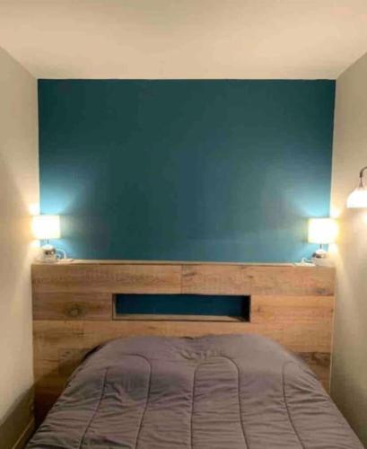 Bett in einem Zimmer mit blauer Wand in der Unterkunft Appartement vue Mer à Porticcio in Porticcio