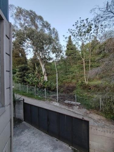 a house with a fence in front of a hill at Villa TG in Batumi