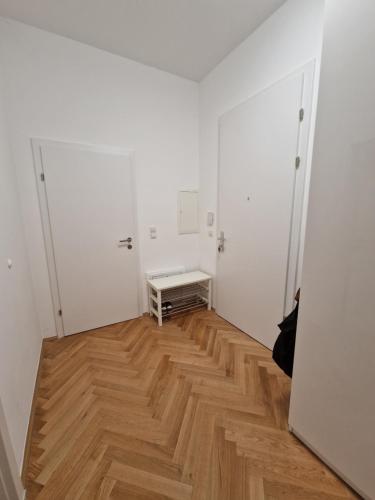 ein leeres Zimmer mit Holzboden und weißen Wänden in der Unterkunft One-Bedroom Apartment with Garden in Wien