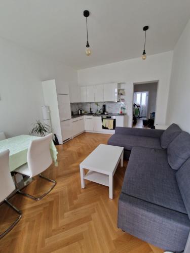 ein Wohnzimmer mit einem Sofa und einem Tisch in der Unterkunft One-Bedroom Apartment with Garden in Wien