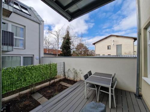 einen Balkon mit einem Tisch und einem Zaun in der Unterkunft One-Bedroom Apartment with Garden in Wien
