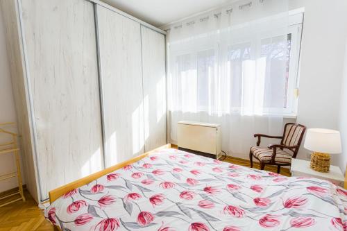 a bedroom with a bed with pink flowers on it at Pionir star in Karaburma