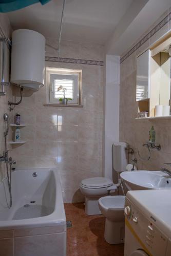 a bathroom with a toilet and a tub and a sink at Dubrovnik Airport Apartment Tea in Durovići