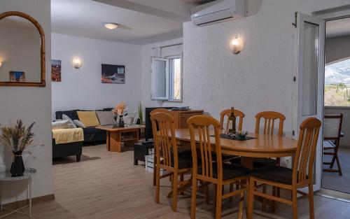 una sala da pranzo e un soggiorno con tavolo e sedie. di Dubrovnik Airport Apartment Tea a Durovići