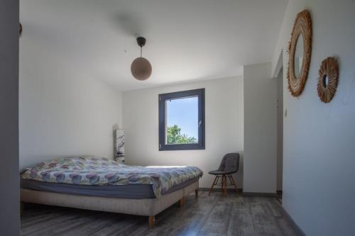 une chambre avec un lit, une fenêtre et une chaise dans l'établissement maison de famille en pleine nature, à La Touche