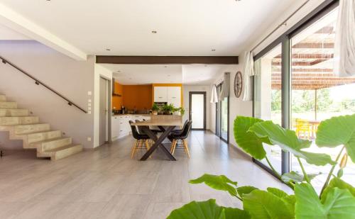 une cuisine et une salle à manger avec une table et des plantes dans l'établissement maison de famille en pleine nature, à La Touche