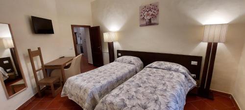 a bedroom with a bed and a table and a mirror at Casa Badia in Radda in Chianti
