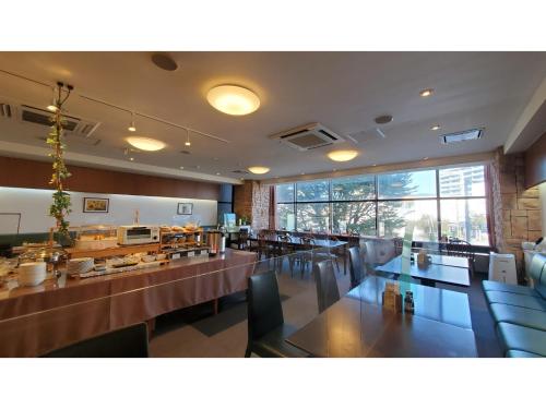 um restaurante com mesas e cadeiras e uma grande janela em Nobeoka Urban-Hotel - Vacation STAY 30532v em Nobeoka