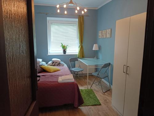 1 dormitorio con cama, escritorio y mesa en Apartament Kopernika, en Gdynia