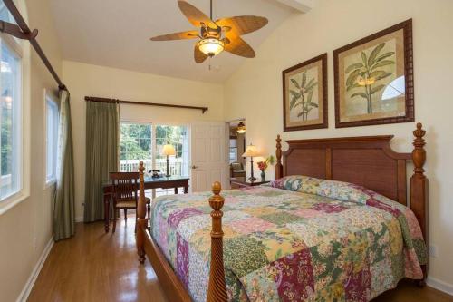 um quarto com uma cama e uma ventoinha de tecto em Beachfront Villa - Garden View Home em Haleiwa