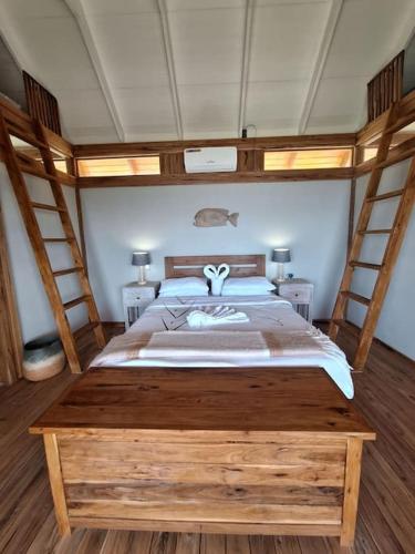 um quarto com uma grande cama de madeira com 2 pessoas em Yothasse Makana Ponta Mamoli em Ponta Mamoli