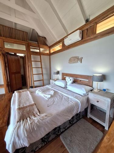 um quarto com uma cama e uma mesa com um candeeiro em Yothasse Makana Ponta Mamoli em Ponta Mamoli