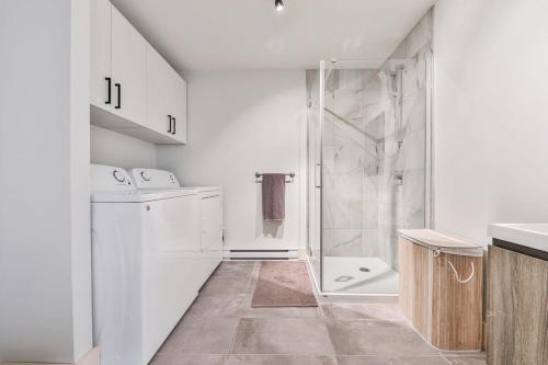 uma casa de banho branca com um chuveiro e um lavatório. em Le Scandinave em Saint Adolphe D'Howard