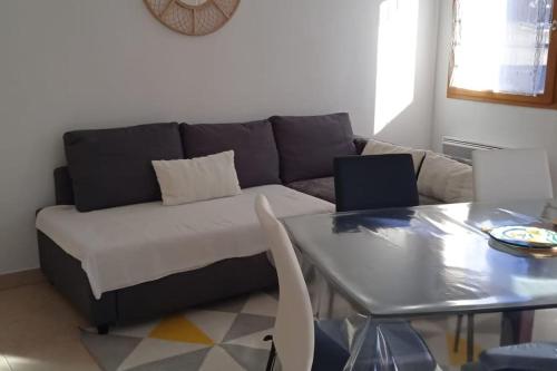 uma sala de estar com um sofá e uma mesa em Appartement station Laye em Laye