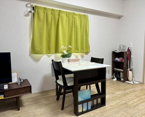 a table and chairs in a room with a green curtain at Rainbow takakura - Vacation STAY 16466 in Nagoya