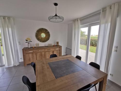 une salle à manger avec une table et un miroir dans l'établissement Maison proche Bayeux, à Saint-Martin-des-Entrées