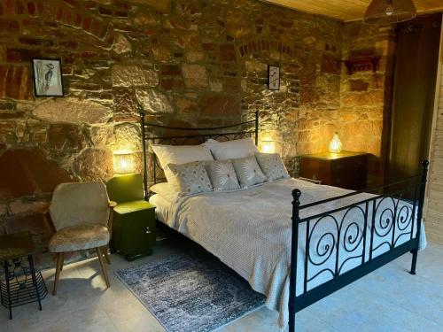um quarto com uma cama e uma parede de pedra em Wozownia Nad Bobrem em Wleń