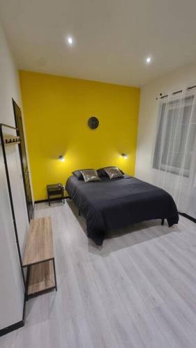 um quarto com uma cama e uma parede amarela em L'Elégance 001 em Cambrai
