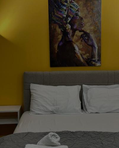 a bedroom with a bed with a painting on the wall at Vila Storia in Niš