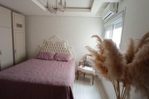 a bedroom with a bed with a pink blanket and a window at Apartamento em Uruguaiana in Uruguaiana