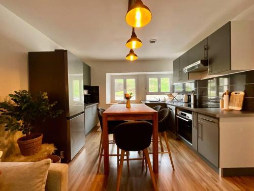 une cuisine avec une table en bois et une salle à manger dans l'établissement Le Refuge de Antoine, 4 étoiles entre pistes et centre-ville, à La Bresse