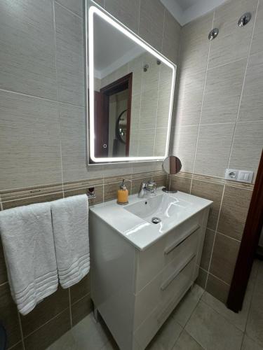 y baño con lavabo blanco y espejo. en Casa Adriana, en San Isidro