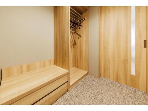 a walk in closet with wooden shelves and a door at Soma Station Hotel - Vacation STAY 40262v in Soma