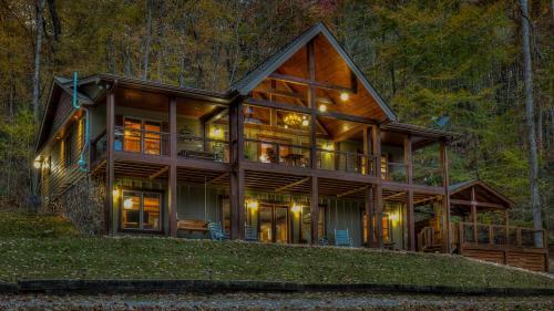 a large wooden house in the woods at night at Meadow Creek Retreat in Cherry Log