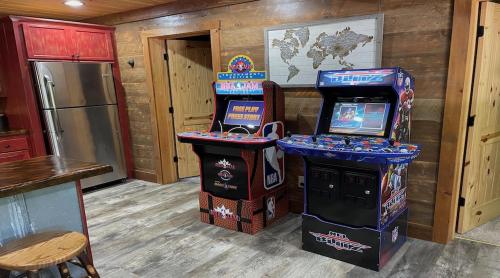 a room with two arcade games and a refrigerator at Meadow Creek Retreat in Cherry Log
