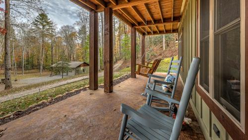 a porch with two chairs and a view of the woods at Meadow Creek Retreat in Cherry Log