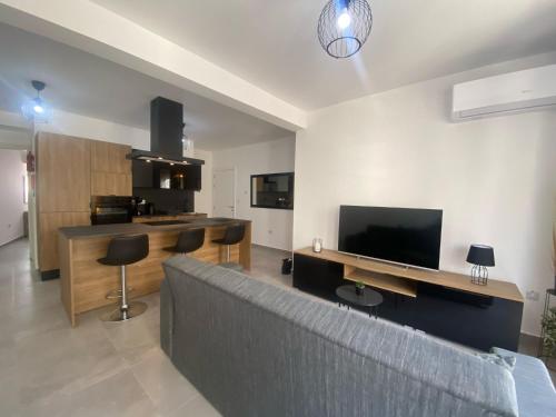ein Wohnzimmer mit einem Sofa und einem Flachbild-TV in der Unterkunft Brand New 2 Bedroom Apartment in Tal-Pietà