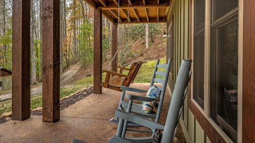 a porch with two blue rocking chairs on a house at Meadow Creek Retreat in Cherry Log