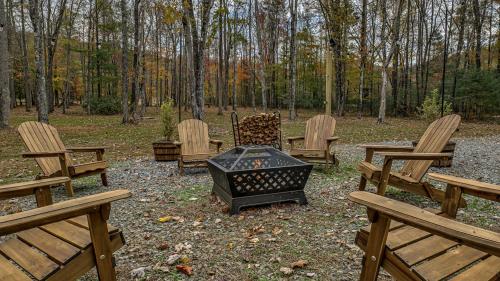 a group of chairs and a fire pit in the woods at Meadow Creek Retreat in Cherry Log