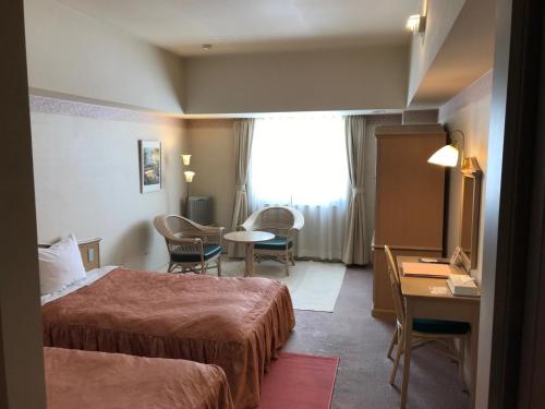 Habitación de hotel con 2 camas, mesa y sillas en Furano Hops Hotel - Vacation STAY 41159v, en Kami-furano