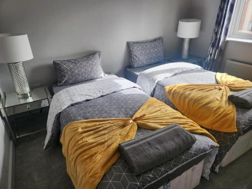 um quarto com 2 camas com lençóis amarelos em Sixty Nines em Dallington