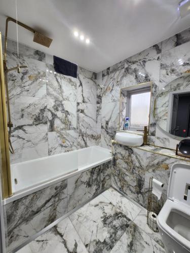 a bathroom with a white tub and a sink at Sixty Nines in Dallington