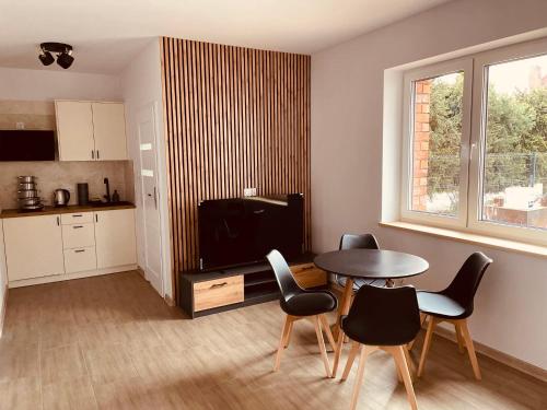 皮什的住宿－Pokoje na Jaśminowej，一间带桌椅的客厅和一间厨房